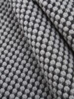 Busk Black wool rug rolled up showing texture