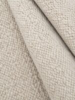 Sandstone wool rug rolled up showing texture